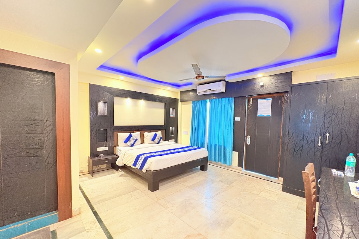 Een hotelkamer met een bed, een plafondventilator, een kledingkast en een deur naar de badkamer.