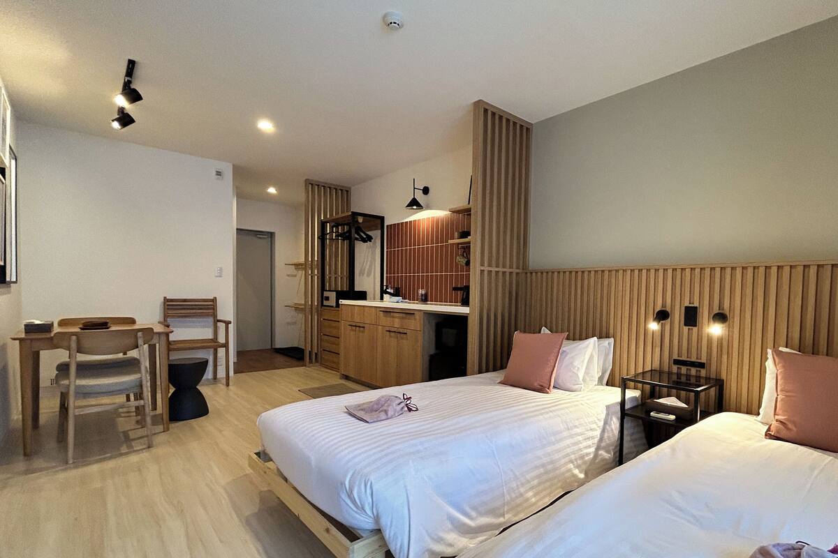 Una habitación de hotel con cama, mesitas de noche, escritorio y una silla.