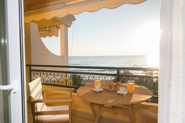 Ein Balkon mit Frühstückstisch, Blick aufs Meer.