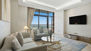Ein modernes Wohnzimmer mit einer Couch, einem Couchtisch und einem an der Wand montierten Fernseher.