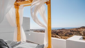 A balcony with a wooden pergola and white curtains, overlooking a rural landscape with a clear sky. - Naxos Aethereal view (Naxos)
