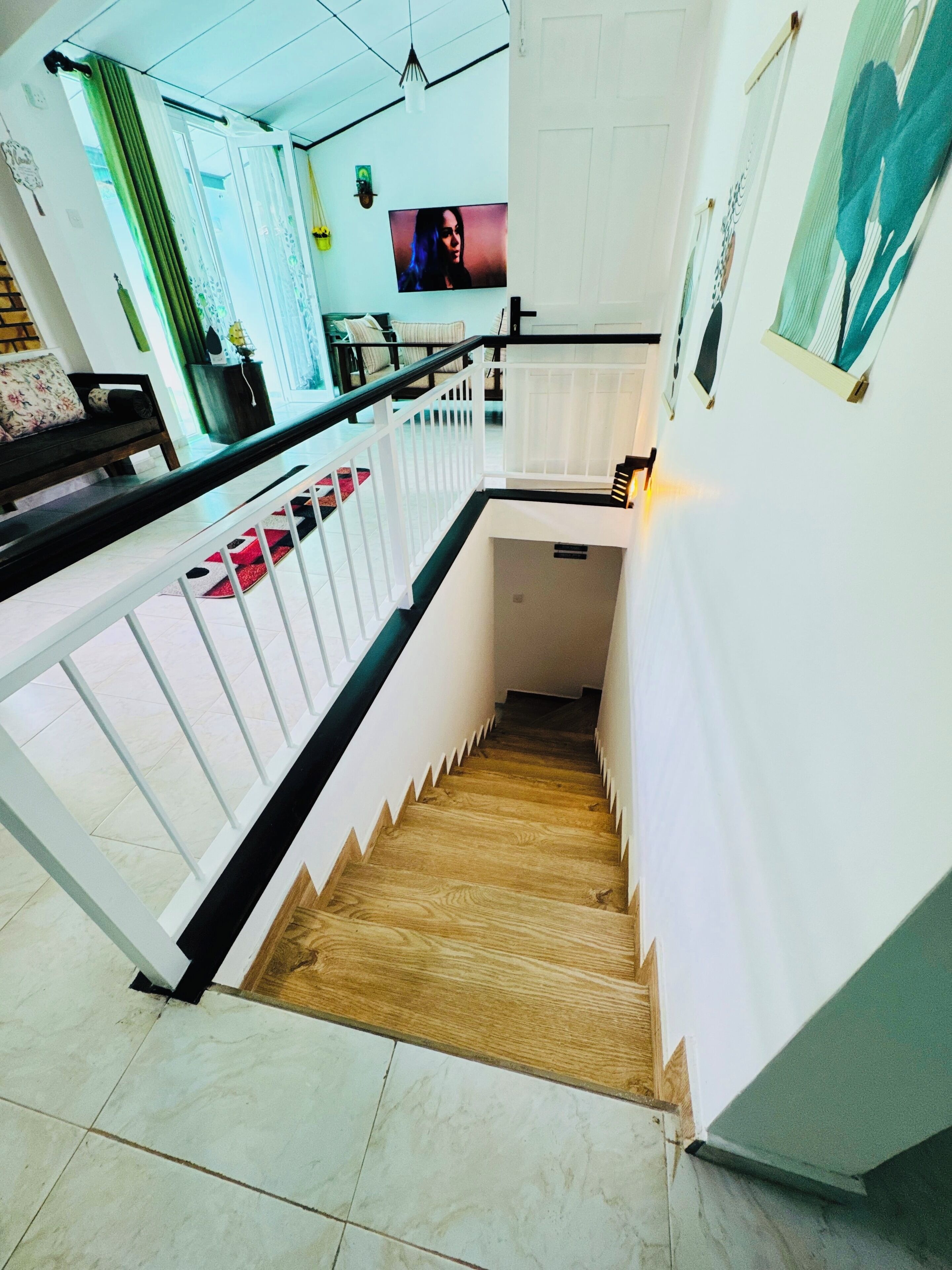 A staircase with white railings and a wooden floor leading to a landing.