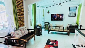 Ein modernes Wohnzimmer mit einer Couch, einem Holztisch und einem an der Wand befestigten Fernseher.