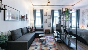 Een moderne woonkamer met een bank, een salontafel, een stapelbed en een bureau.