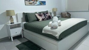 A neatly arranged bedroom with a bed, two bedside tables, and a nightstand. - Beautiful 2R2B apartment in Playa Bibijagua, Punta Cana (Punta Cana)