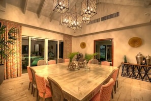 A spacious dining area with a large wooden table, patterned chairs, and decorative vases. - Cap Cana's most coveted villa with 8 bedrooms (Punta Cana)
