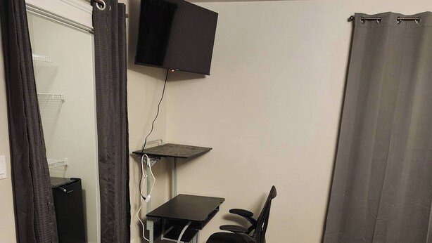 A compact room with a desk, chair, and TV. - Room-private Master Room in a Quiet Hous (Woodstock)