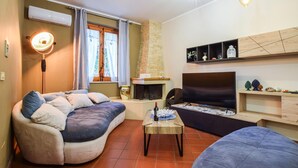 A cozy living room with a sofa, a coffee table, a fireplace, and a TV. - Stunning home in Altavilla Milicia (Altavilla Milicia)