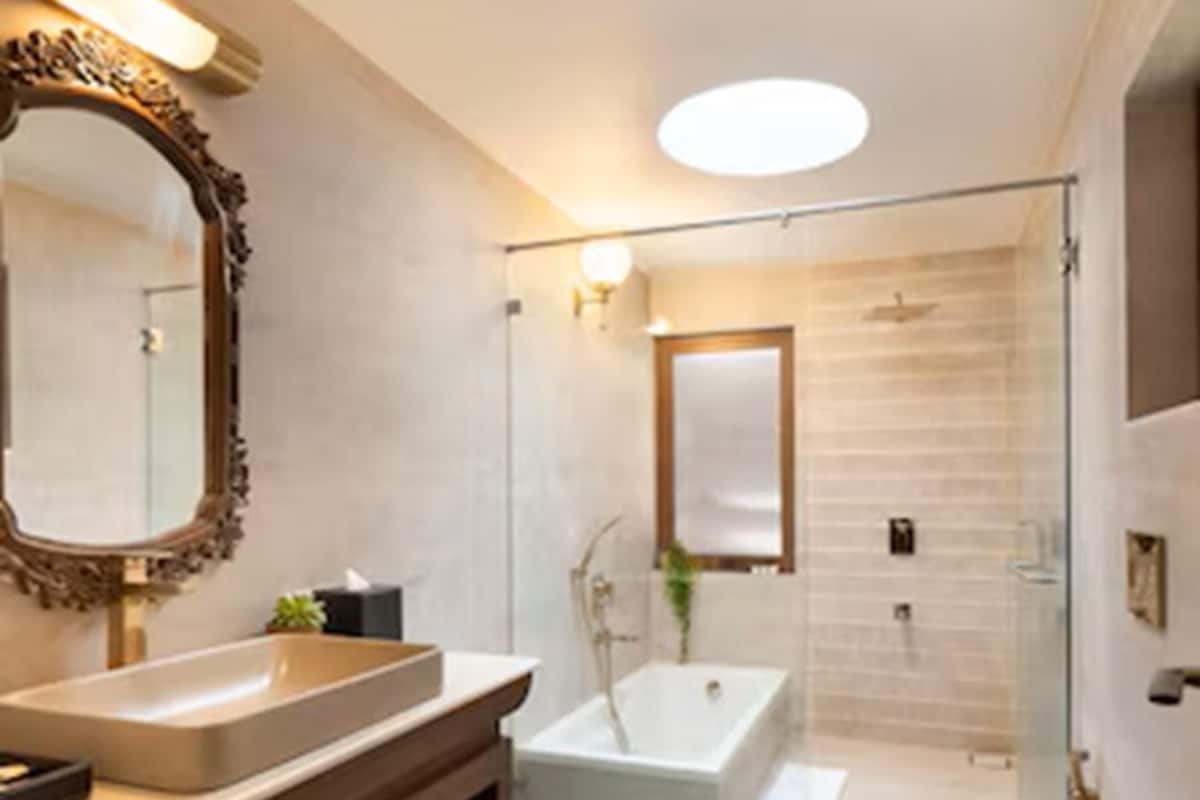 A modern bathroom with a large vanity, a freestanding bathtub, and a glass shower enclosure.