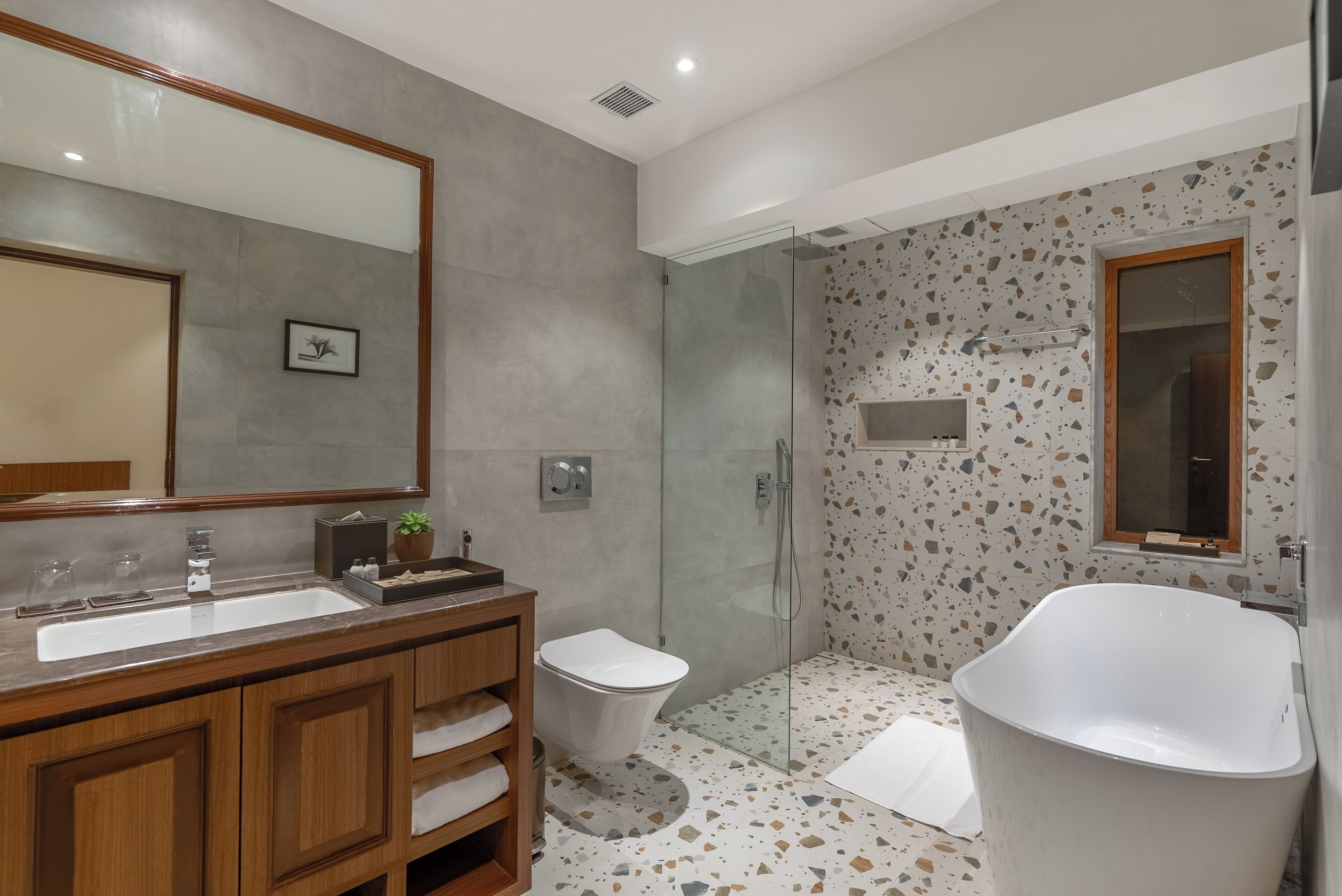 A modern bathroom with a large sink, vanity, and a freestanding bathtub.