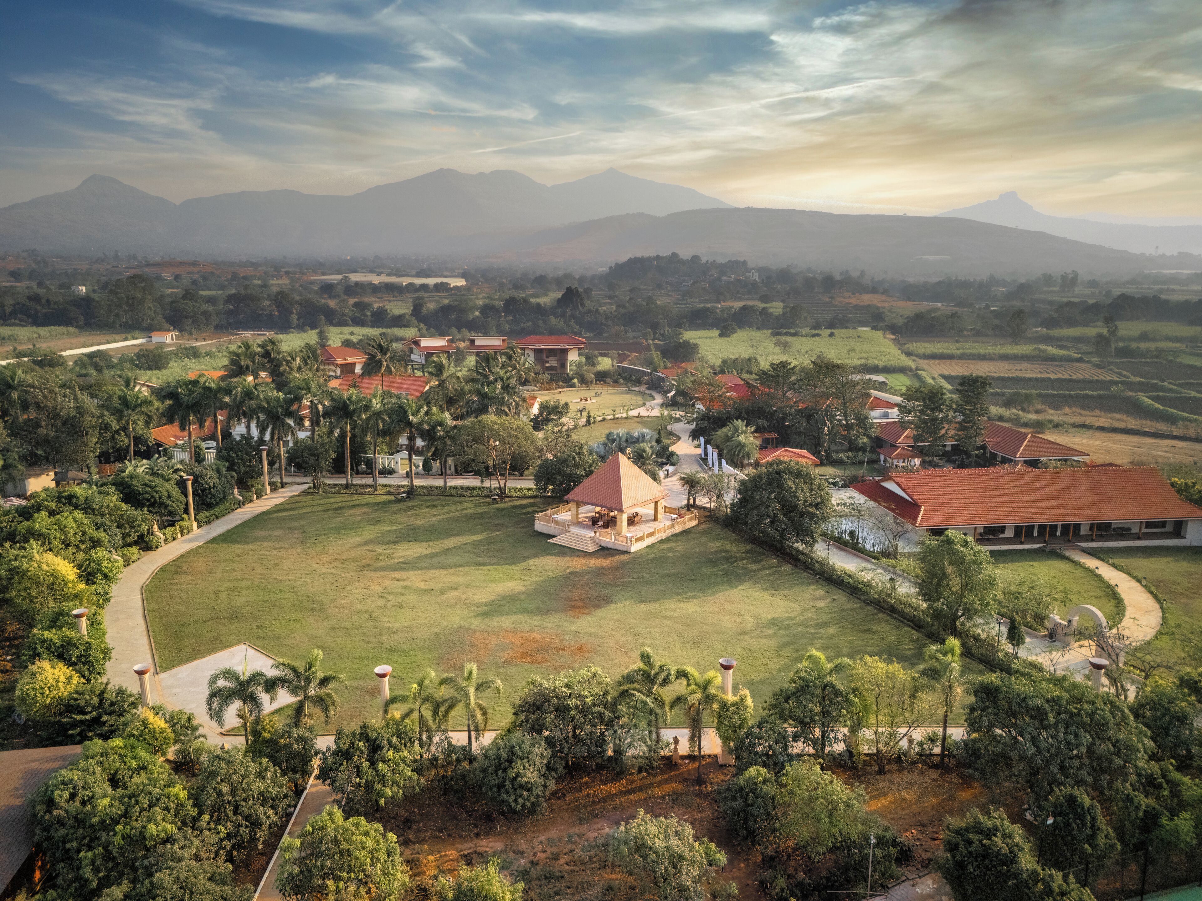 A large estate with multiple buildings, a central pavilion, and surrounding greenery.