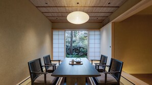Una habitación tradicional japonesa con suelo de tatami, una mesa de madera baja y puertas correderas shoji.