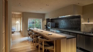 Una cocina moderna con una isla grande, taburetes de bar, un microondas y un lavaplatos.