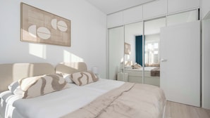 A bedroom with a bed, a wardrobe, and a mirror. - Apartment on the Market Square | In the Heart of the Old Town (Wrocław)
