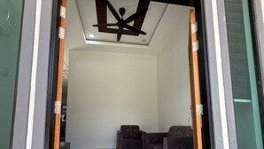 A modern interior with a ceiling fan, a patterned rug, and two sofas. - Homestay Selesa KLS Guest House (Kuala Terengganu)