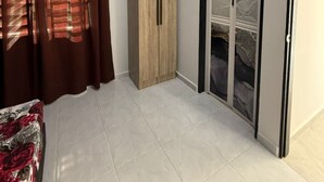 A room with a bed, a wardrobe, and a door with a view. - Homestay Selesa KLS Guest House (Kuala Terengganu)