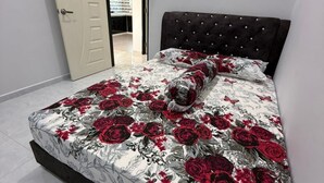 A bedroom with a bed, a door, and a view of a bathroom. - Homestay Selesa KLS Guest House (Kuala Terengganu)