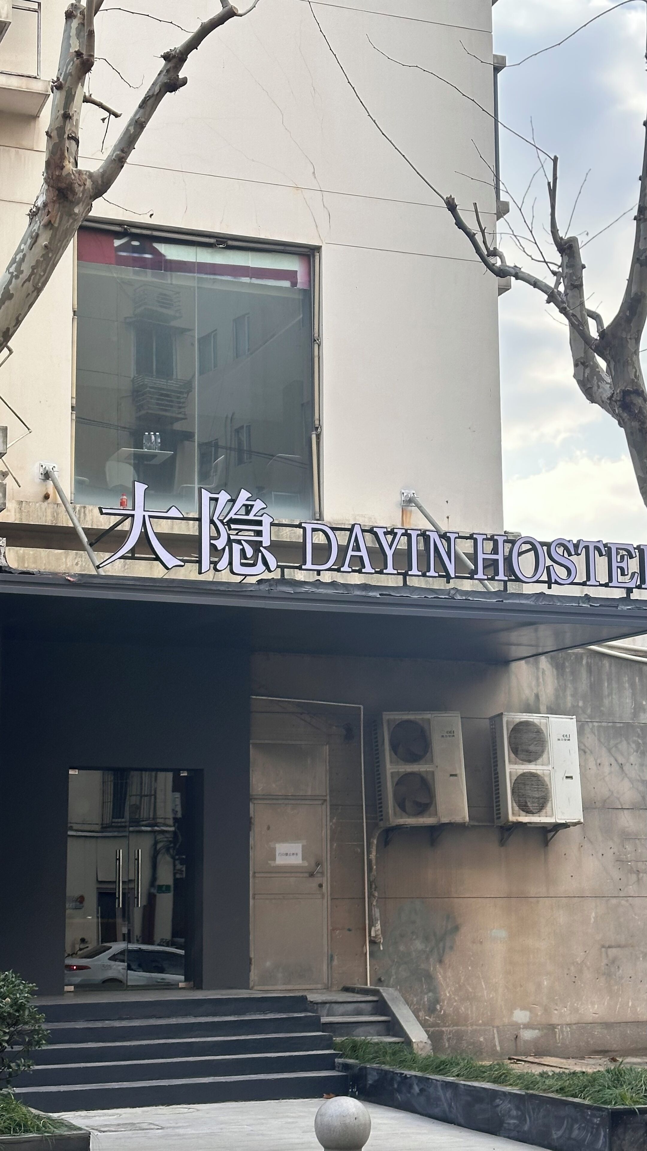 Um edifício com uma placa que diz "DAIINHOSTEL".