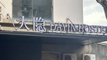 Um edifício com uma placa que diz "DAIINHOSTEL".