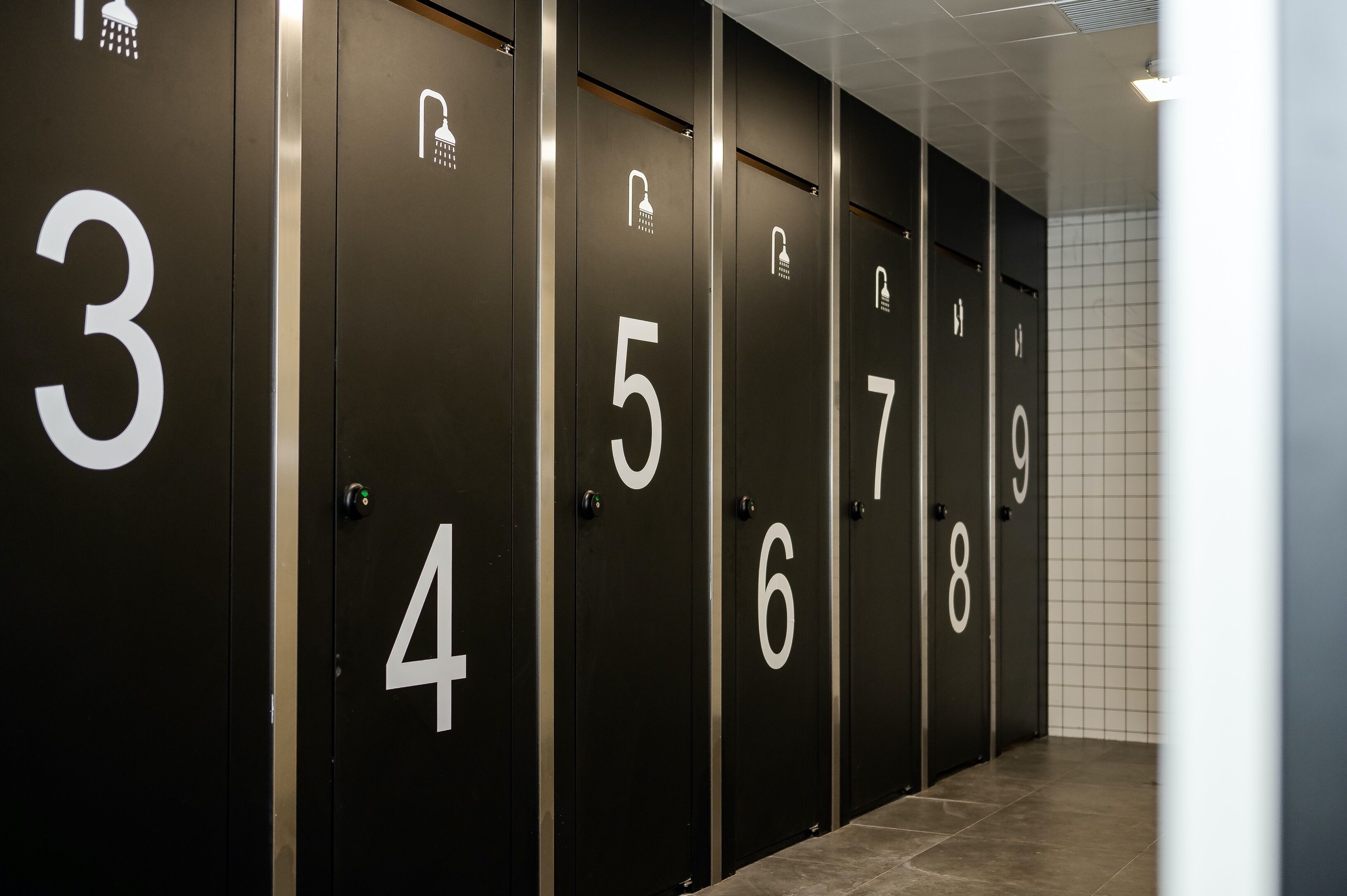A row of black lockers numbered 3 to 9, with shower icons above each number.