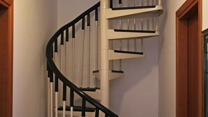 A spiral staircase with white railings and black handrails, leading to an upper floor. - Spacious Villa with Garden, WiFI, A/C, Outdoor kitchen, short walk to the Sea (Piana Calzata)