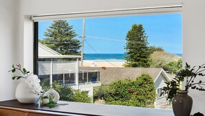 A view from a window overlooking a beach with houses and trees.
