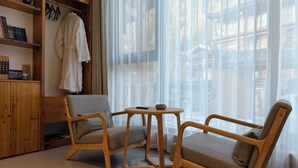 A cozy room with a wooden cabinet, a sofa, a round table, and sheer curtains. - Zhangjiajie Zhiguiju (Zhangjiajie)