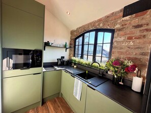 Een koelkast, een magnetron, een kookplaat, een vaatwasser