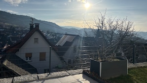 Zona residencial amb cases, cel blau i sol ponent o sortint.