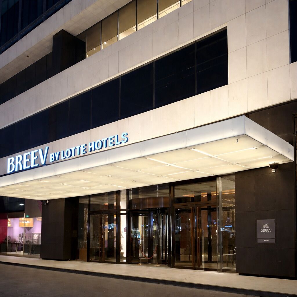 Entrada de un hotel con un cartel que dice 'BREEV BY LOTTE HOTELS'.