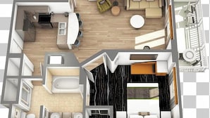 Ein Grundriss eines Hotelzimmers mit einer Küchenzeile, einem Wohnbereich mit Sofa und Esstisch, einem separaten Schlafzimmer mit Bett sowie einem Badezimmer mit Badewanne und Toilette.