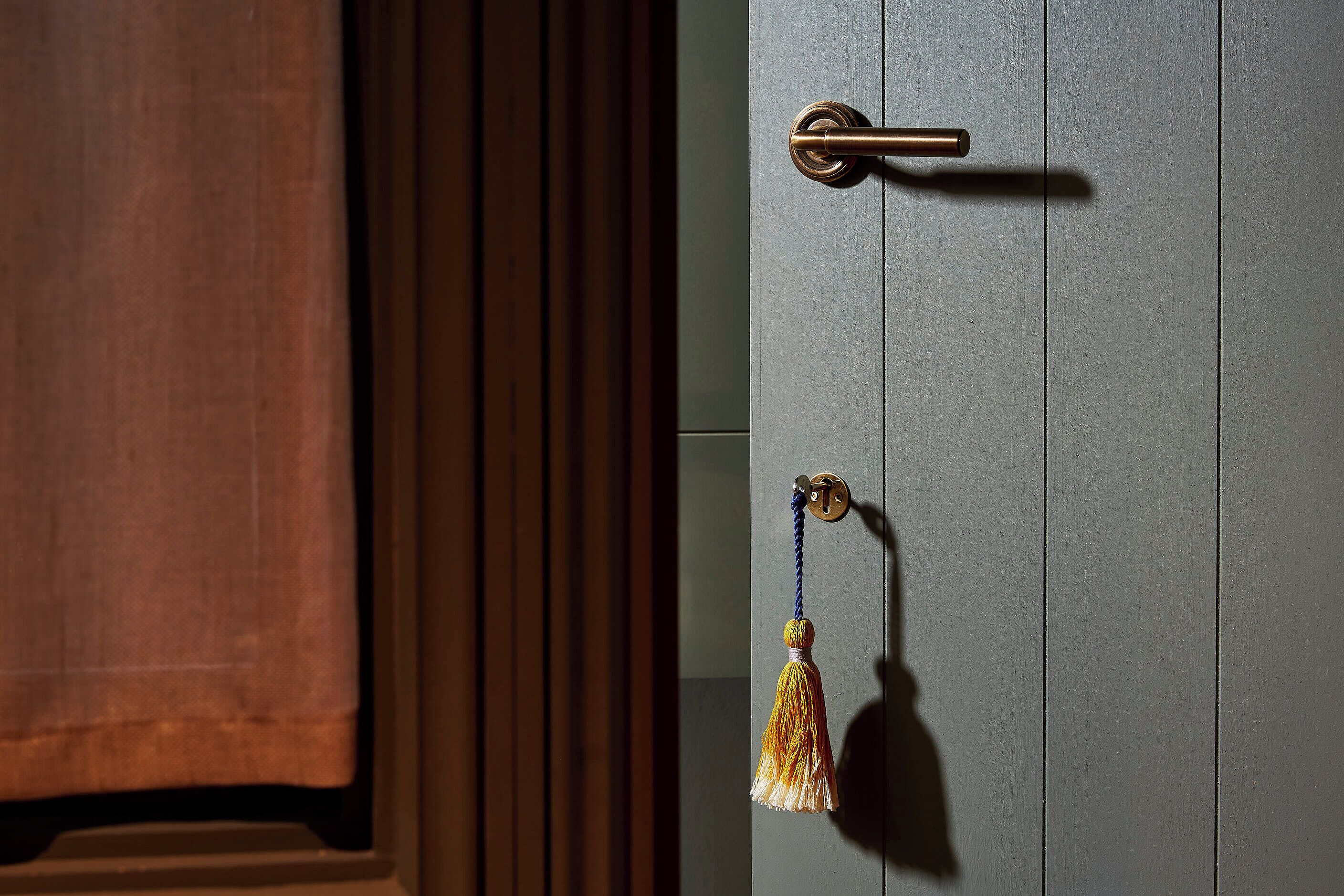A door with a brass handle and a brass lock.