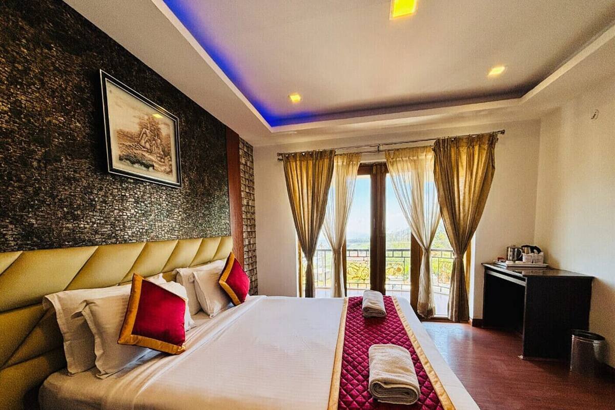 Une chambre d’hôtel avec un grand lit, un bureau et une vue sur l’extérieur.