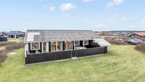 A modern, single-story house with a sloped roof, large windows, and a fenced yard. - "Alvia" - 250m from the sea by Interhome (Løkken)