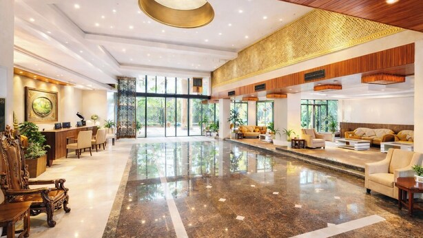 A spacious lobby with a polished marble floor, wooden reception desk, and comfortable seating areas. - OPO Horizon Anant Ayodhya (Faizabad)
