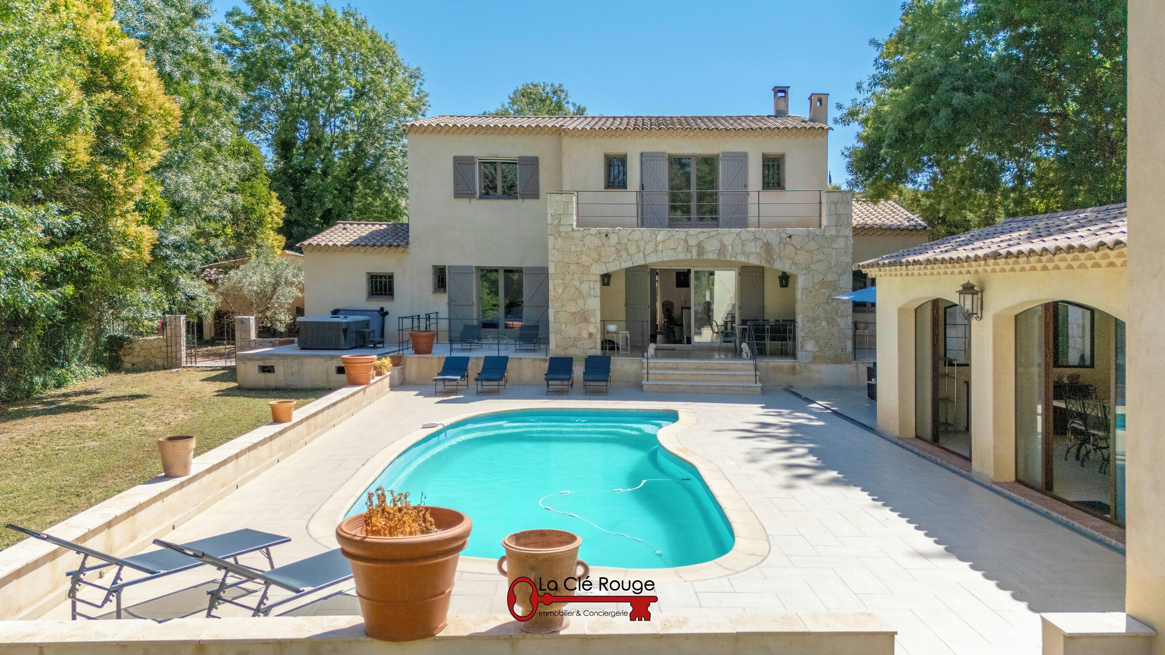 Ein zweistöckiges Haus mit Swimmingpool, Außenbereich und einer Steinfassade.