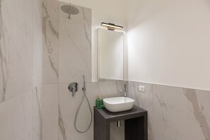 Regadera, secadora de cabello, toallas, papel de baño 