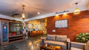 A cozy lobby with a sofa, a chess table, and a reception desk. - LiveAway Rishikesh Laxman Jhula by PACK (Rishikesh)