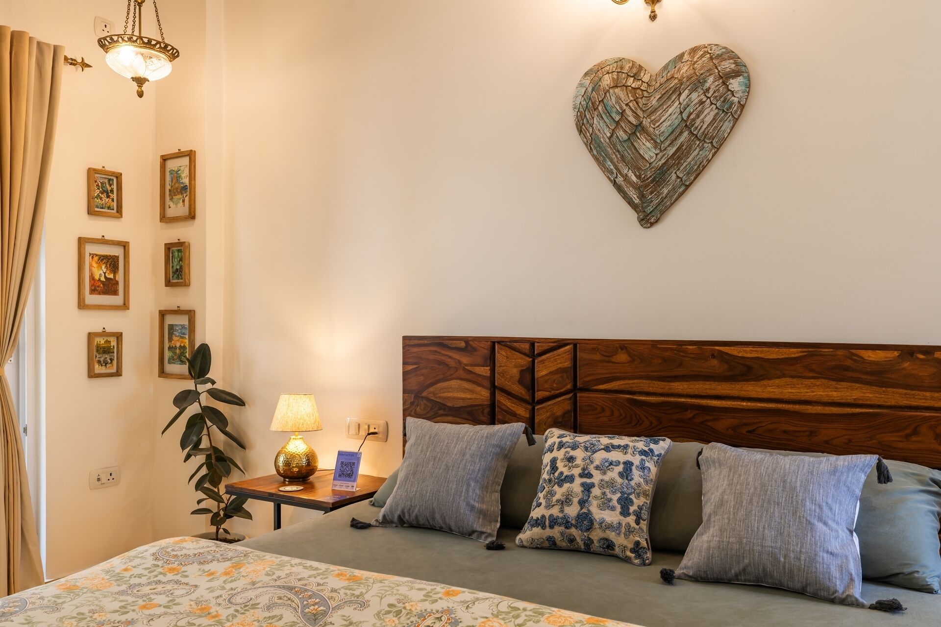 A bedroom with a wooden headboard, a heart-shaped wall decoration, and a bed with floral bedding.