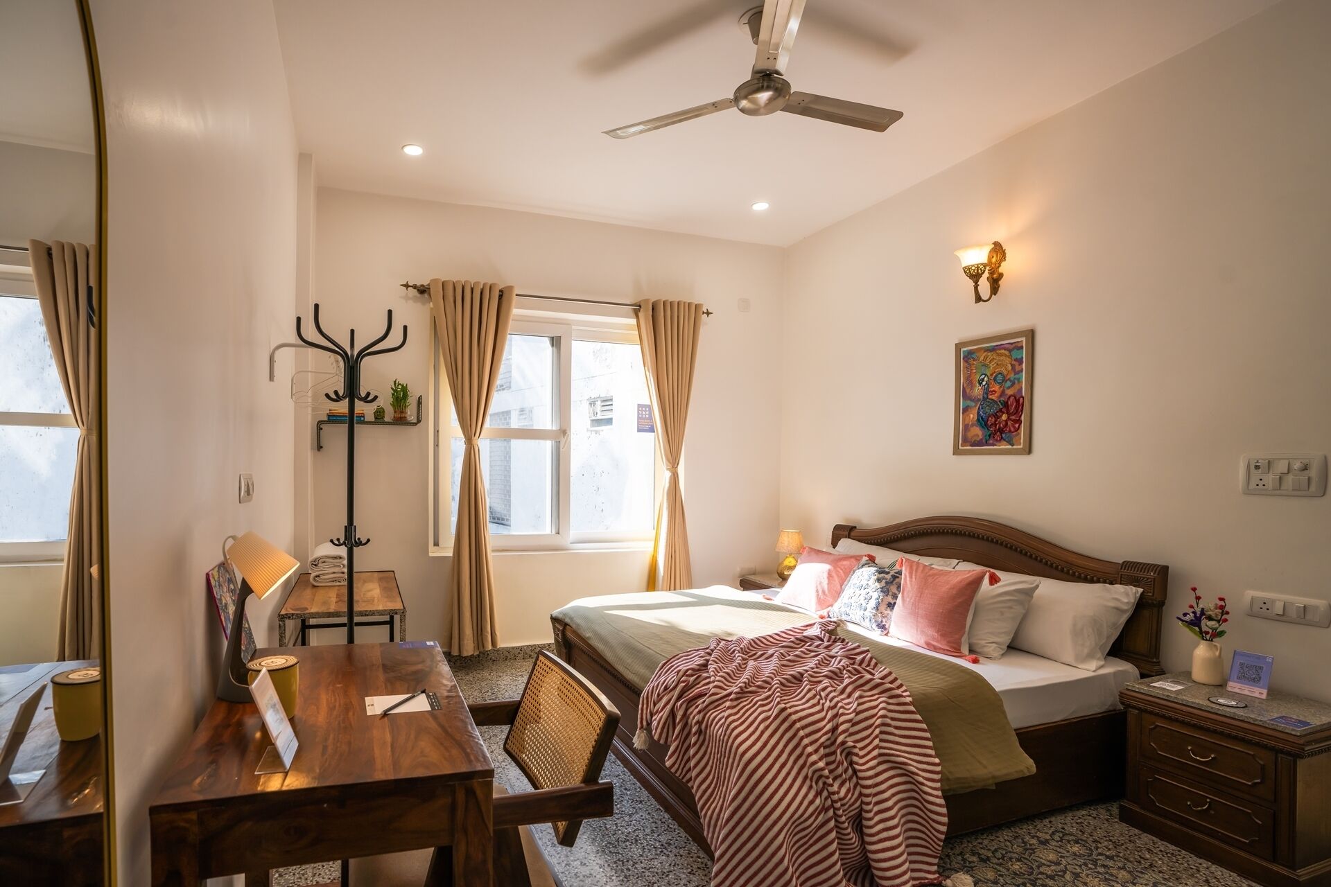 A bedroom with a bed, bedside table, lamp, and a ceiling fan.
