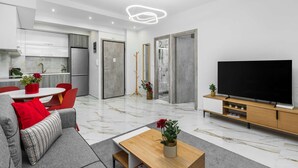 A modern living room with a sofa, coffee table, and a TV on a wooden stand. - Eleanor by halu! - 1-BD Apartment next to Hagia Sophia (Thessaloniki)