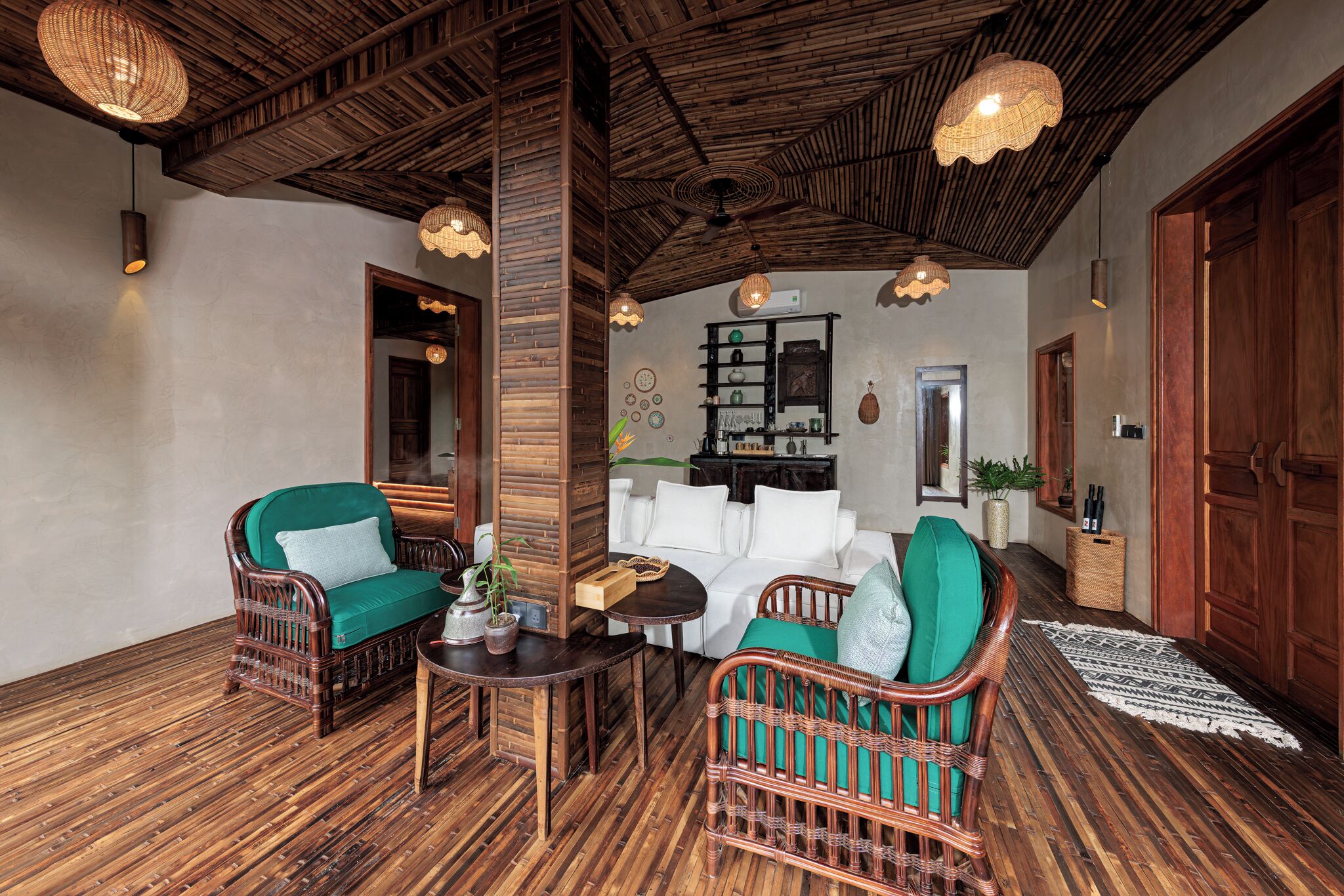 A cozy room with wicker furniture, a wooden ceiling, and a small table with a vase.