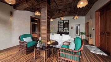 A cozy room with wicker furniture, a wooden ceiling, and a small table with a vase.