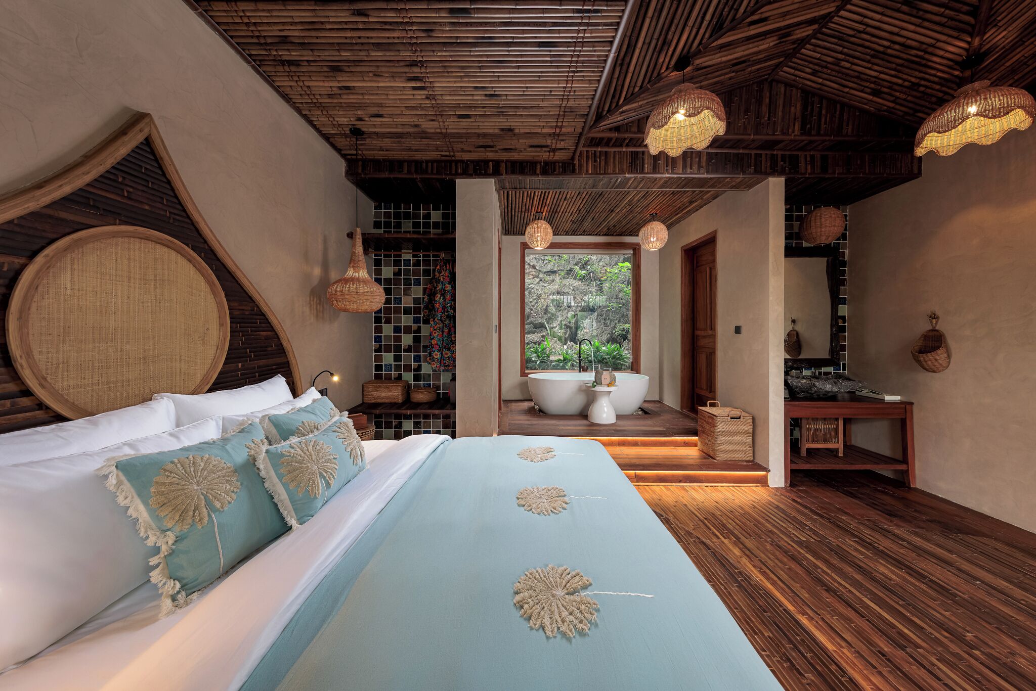 A bedroom with a large bed, a wooden ceiling, and a view of a bathroom.