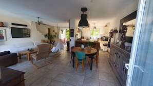 Un grand espace de vie comprenant un canapé, une table à manger et une cuisine à l’arrière-plan.