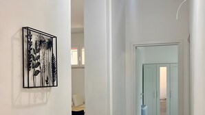 Un couloir au design moderne, avec des murs blancs et un sol carrelé.