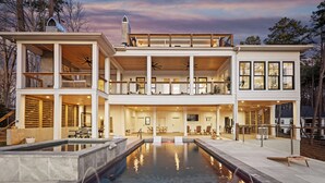 A two-story house with a large outdoor swimming pool, multiple balconies, and a spacious patio area. - Waterfront Estate + Dock + Pool | Game Room | Sleeps 16 | Southern Belle Estate (Mooresville)