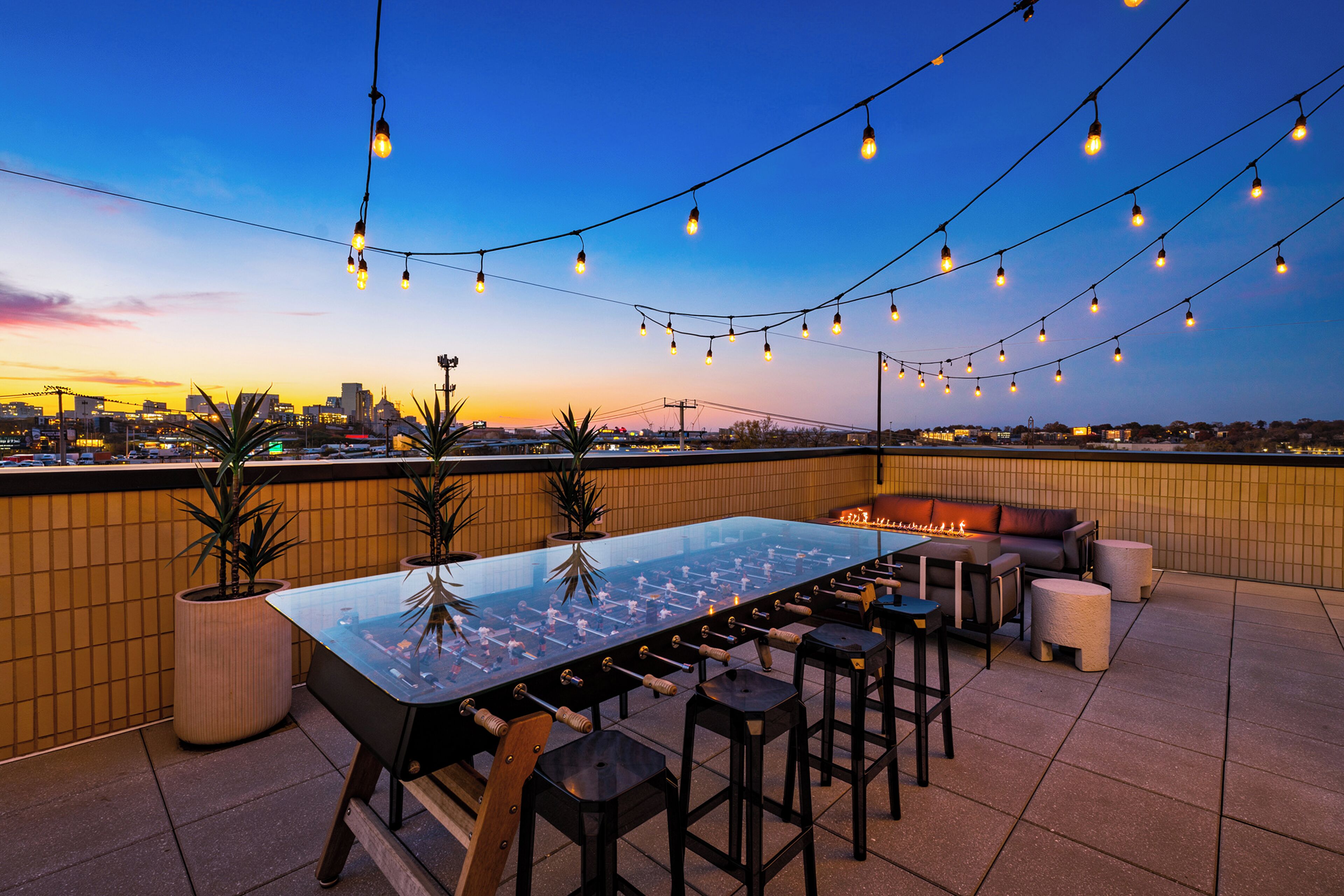 Relax under café lights on the rooftop patio, featuring plush lounge seating, a sleek fire pit, a foosball table and space to gather after a day in Nashville.