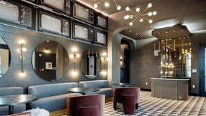 Un espace de détente moderne, doté de sièges, d’un comptoir d’accueil et d’un sol à motifs.