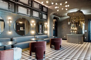 Ein moderner Loungesesselbereich mit Sitzgelegenheiten, einer Rezeption und einem gemusterten Boden.